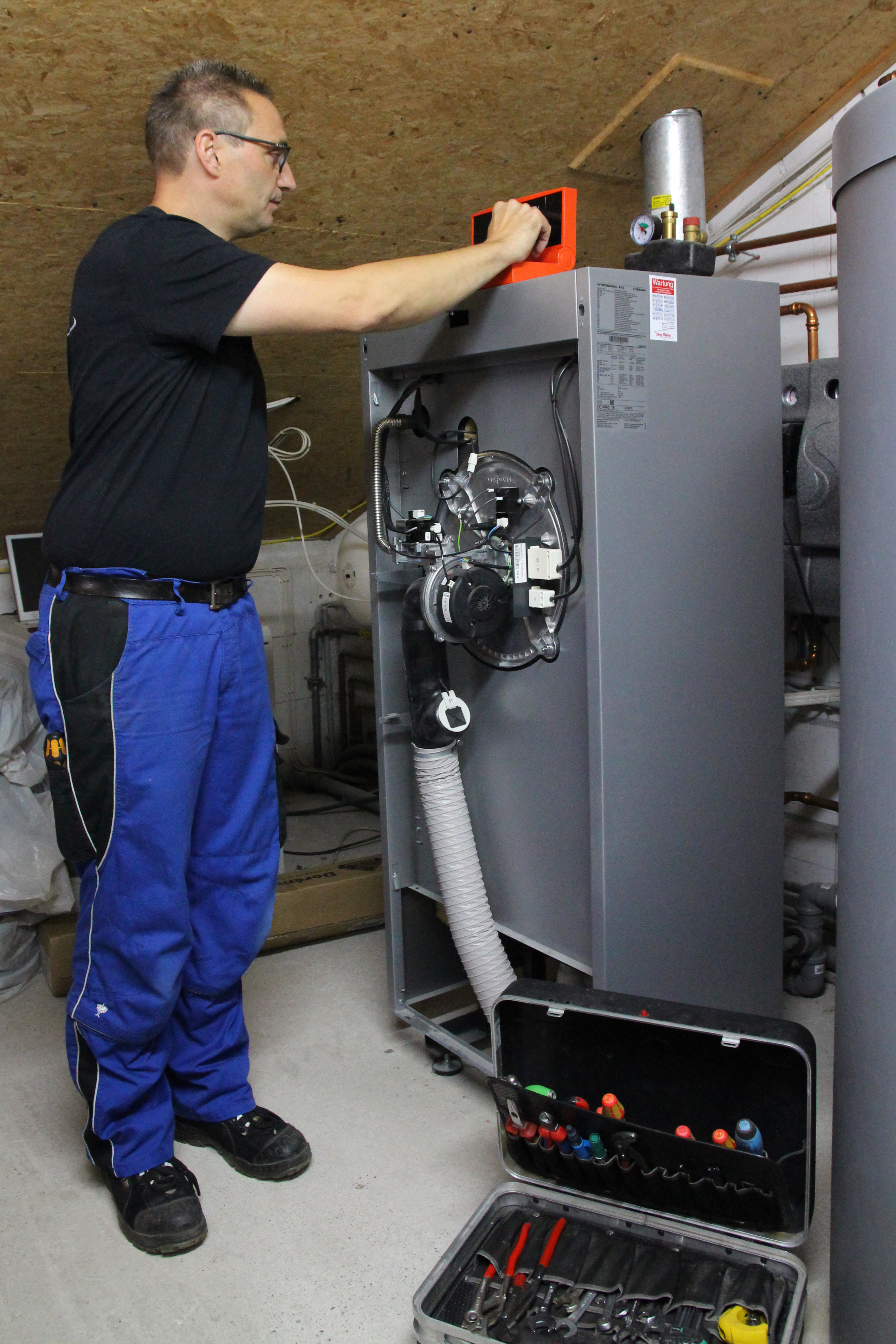 Mitarbeiter arbeitet an einer Heizungsanlage
